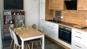 A modern kitchen with white cabinets, a wooden countertop, and a built-in oven. - 1 bedroom stunning apartment in Graal Müritz (Graal Müritz)