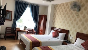 A hotel room with two beds, a desk, a chair, a wardrobe, and a television. - New Day Hotel Quy Nhon (Quy Nhon Nam)