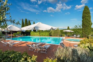A rectangular swimming pool with multiple lounge chairs and umbrellas, surrounded by greenery and trees. - Lovely apartment with WIFI, A/C, pool, TV, terrace and panoramic view, close to San Gimignano (Sughera)