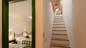 A staircase leading to a bedroom with two beds, each with a plaid bedspread. - Cosy apartment with A/C, pool, WIFI, TV, veranda and panoramic view, close to San Gimignano (Sughera)