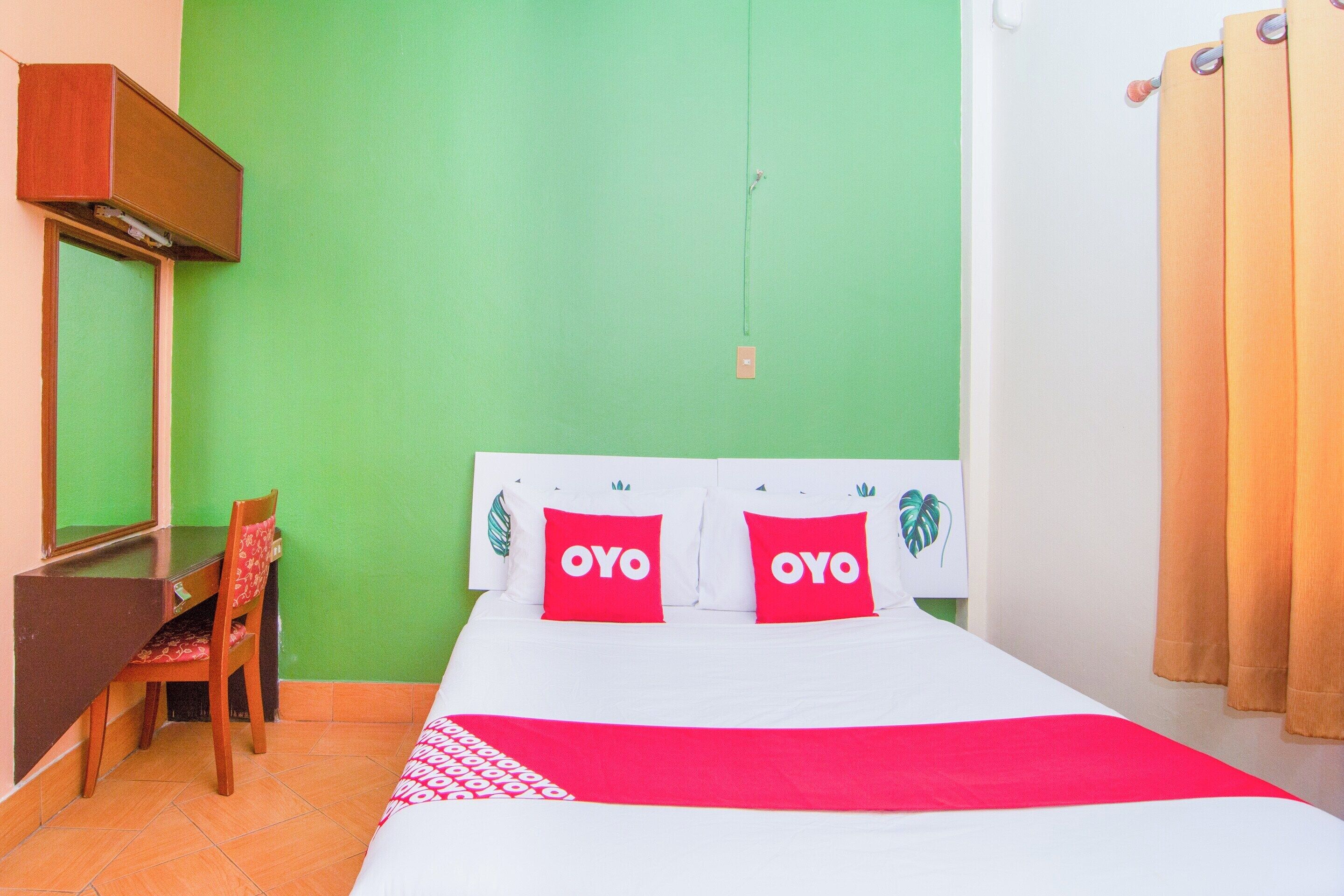 Una habitación con cama, escritorio y silla.