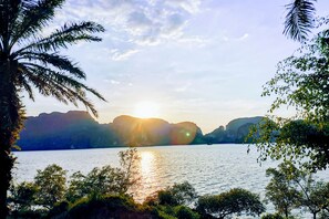 A serene lakeside view with mountains in the background and palm trees in the foreground. - OYO Bulan Anda Baba Resort (Ao Luek)
