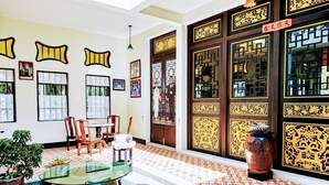 A room with a glass table, chairs, a potted plant, and a large decorative vase. - OYO Bulan Anda Baba Resort (Ao Luek)