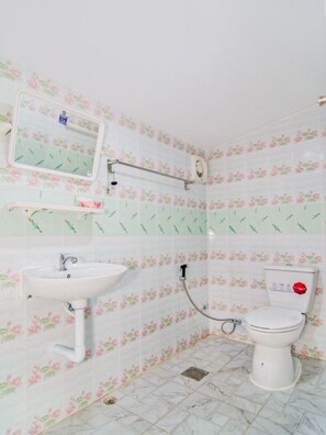 A bathroom with a toilet, sink, and mirror.