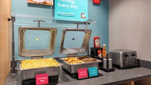 A breakfast buffet with labeled containers for scrambled eggs, potatoes, turkey sausage, and other items. - avid hotel Midland by IHG (Midland)