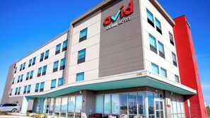 A modern hotel building with a prominent 'ovid' sign, multiple windows, and a red accent wall. - avid hotel Midland by IHG (Midland)