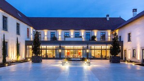 A modern hotel with a spacious courtyard, large windows, and a well-lit entrance. - Best Western Premier Hotel & Spa Les Sept Fontaines (Tournus)