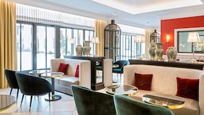 A modern hotel lobby with a sofa, chairs, a coffee table, and decorative vases. - Best Western Premier Hotel & Spa Les Sept Fontaines (Tournus)