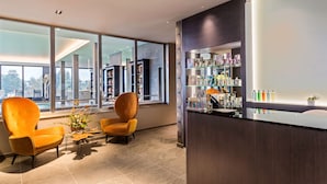 A modern hotel lobby with large windows, a reception desk, and two orange armchairs. - Best Western Premier Hotel & Spa Les Sept Fontaines (Tournus)