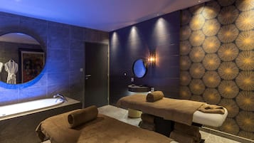 Relax in a serene spa room with a massage table, wall-mounted massage area, and a spacious sink area.