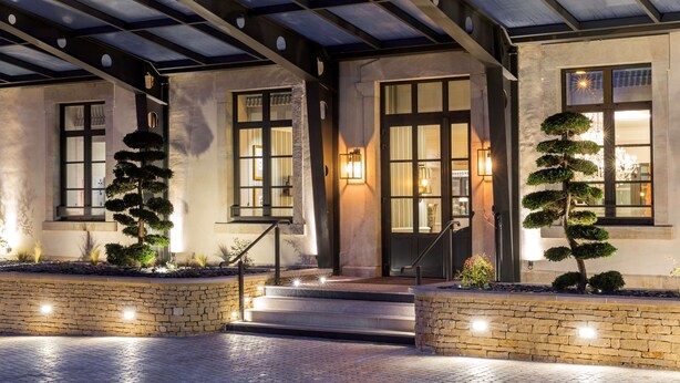 A building with a covered entrance, stone steps, and two well-maintained bonsai trees. - Best Western Premier Hotel & Spa Les Sept Fontaines (Tournus)
