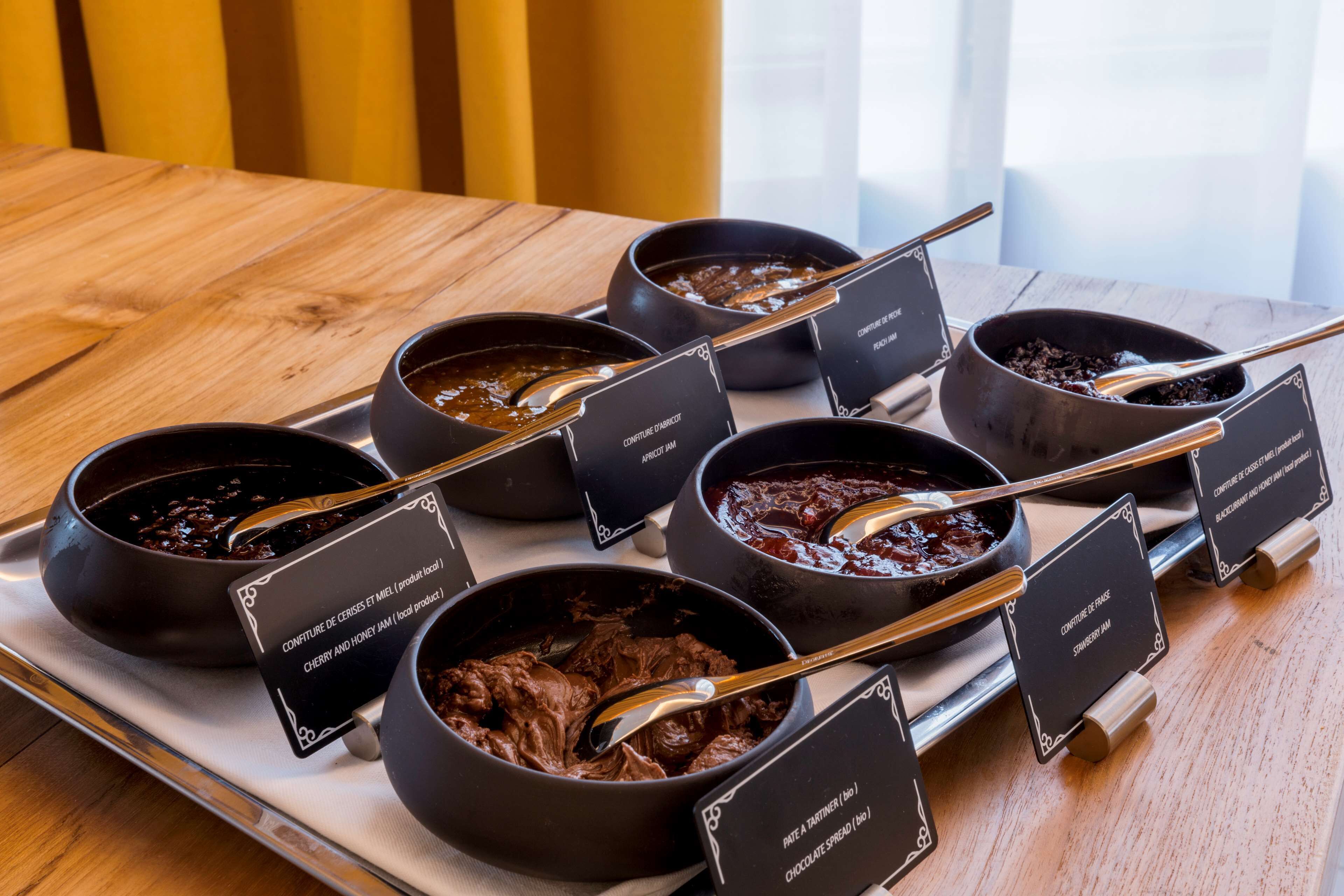 A tray of bowls with different types of spreads, each labeled with their names.
