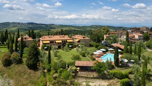 Une villa dotée d’une piscine, entourée d’une végétation luxuriante et offrant une vue sur des collines ondoyantes.