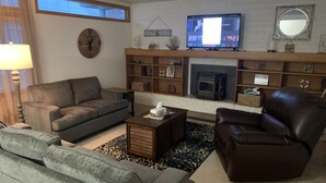 Ein Wohnzimmer mit Kamin, Fernseher und einer Wanduhr.
