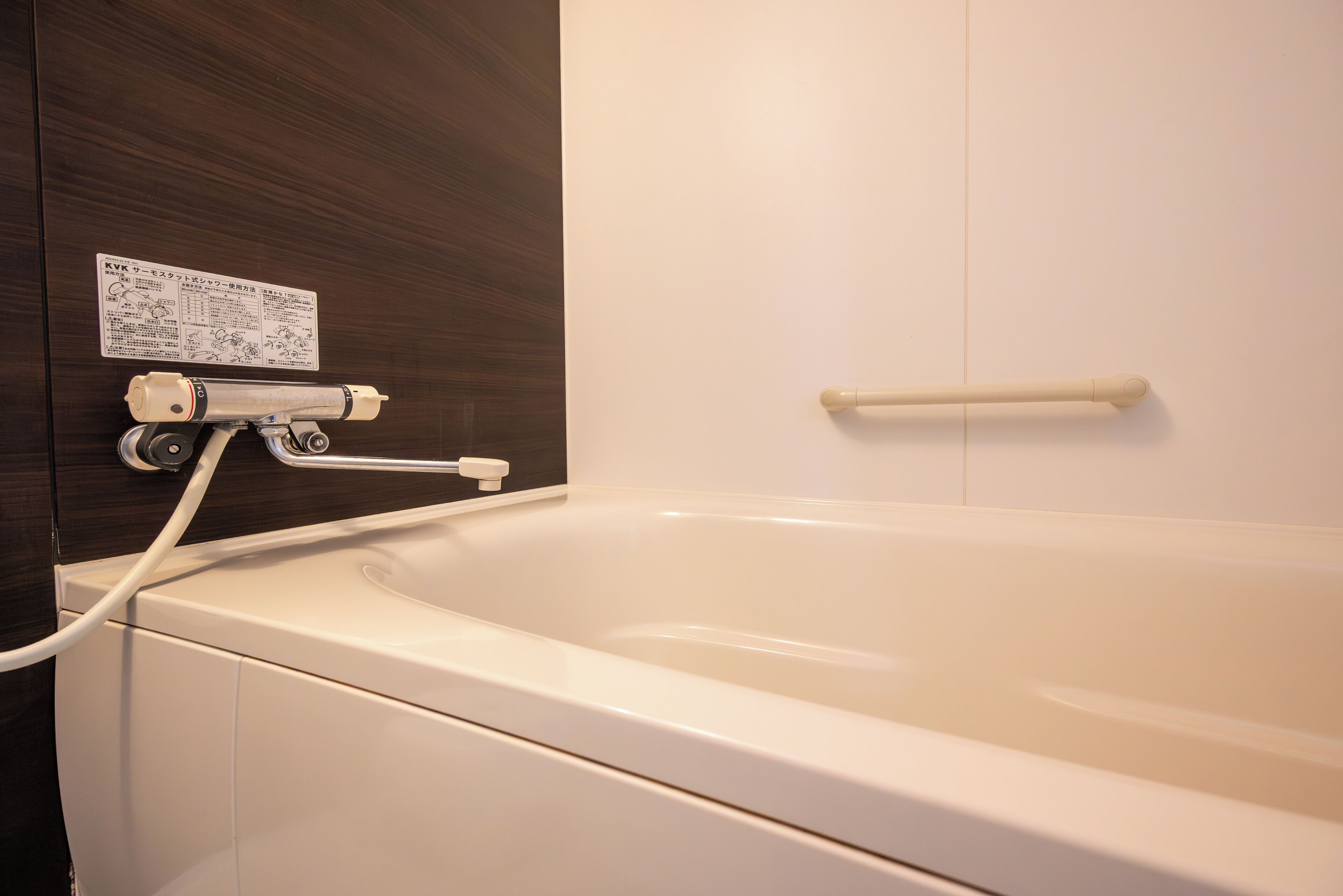 Una bañera con panel de control y barandilla.
