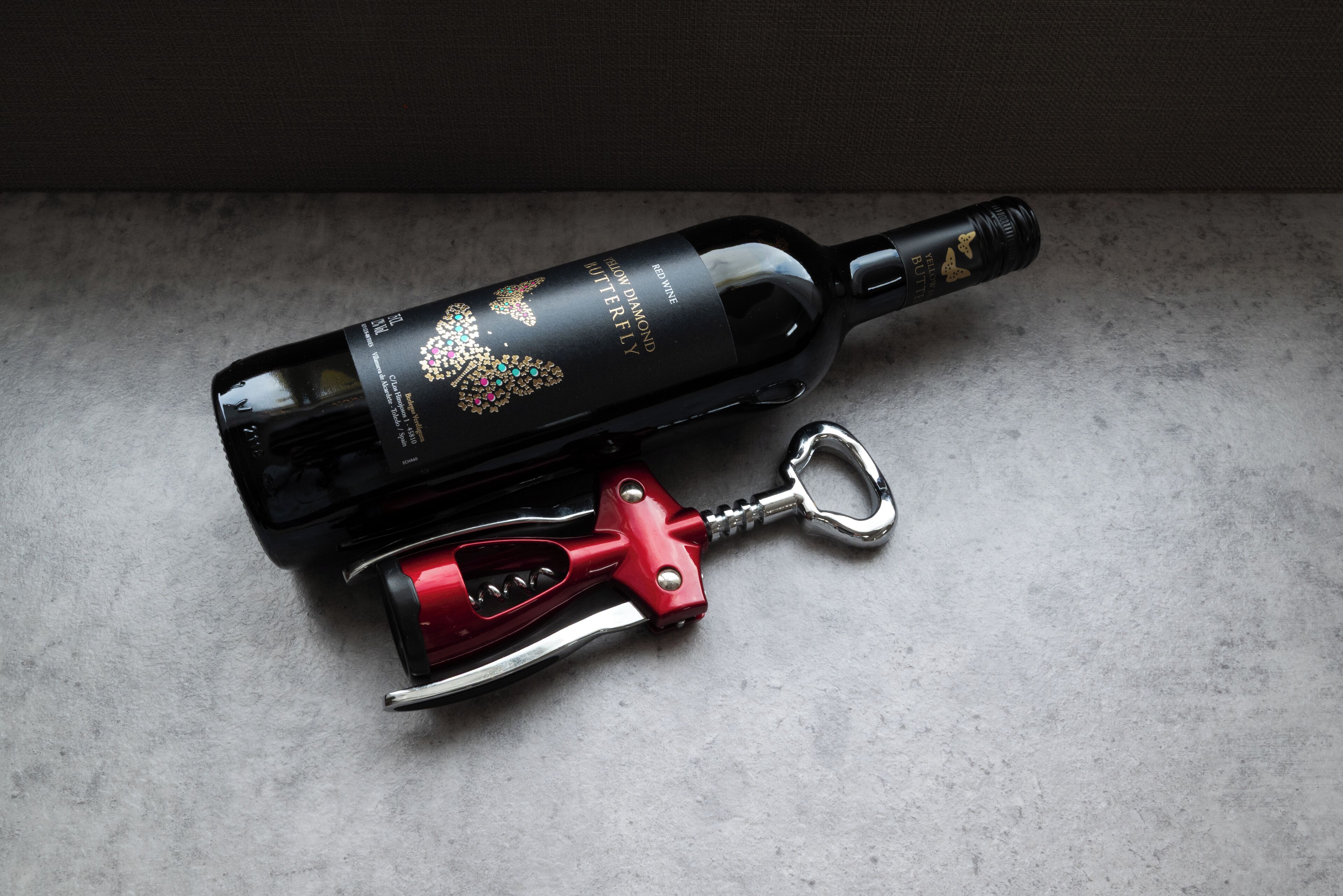 A wine bottle with a corkscrew and a decorative label.