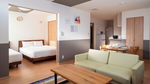Een moderne kamer met een bed, een bank, een eettafel en een keukenhoek.