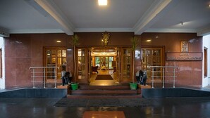 The entrance of Hotel Kodai International with a grand reception area, a central statue, and a signboard. - Hotel Kodai International (Kodaikanal)