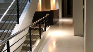 A modern interior with a staircase, a hallway, and a reception area. - Golite Hostel-Albay (Legazpi)