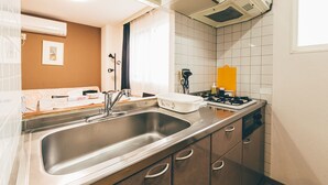 A modern kitchen with a stainless steel sink, a stove, and a microwave. - Stay in Otaru (Otaru)