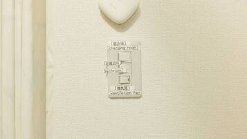 A control panel with labels for a changing room, bathroom, and ventilation fan.