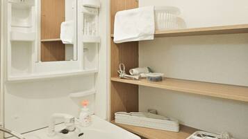 A bathroom with a sink, mirror, shelves with toiletries, and a towel rack.