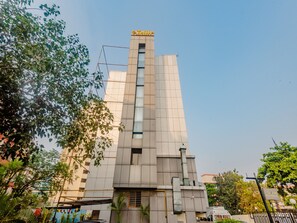 A modern building with a prominent vertical feature and a sign indicating it is a 'Tulp Residency'. - Tuliip Residency (Mumbai)