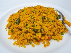 A plate of yellow rice with beans and herbs. - Tuliip Residency (Mumbai)
