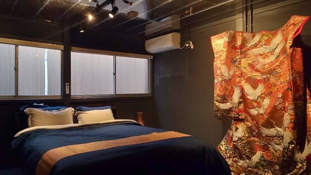 A room with a bed, large windows, and a curtain with a bird pattern. - Bettei Shinimamiya (Osaka)