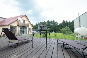 Relax on the deck with two lounge chairs and a small table, surrounded by scenic views of the trees.
