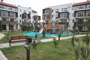 Residents can enjoy a playground with a slide and play structures in a central green space.