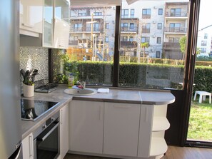 Enjoy a kitchen with a large window offering views of the surrounding area, oven, and sink.