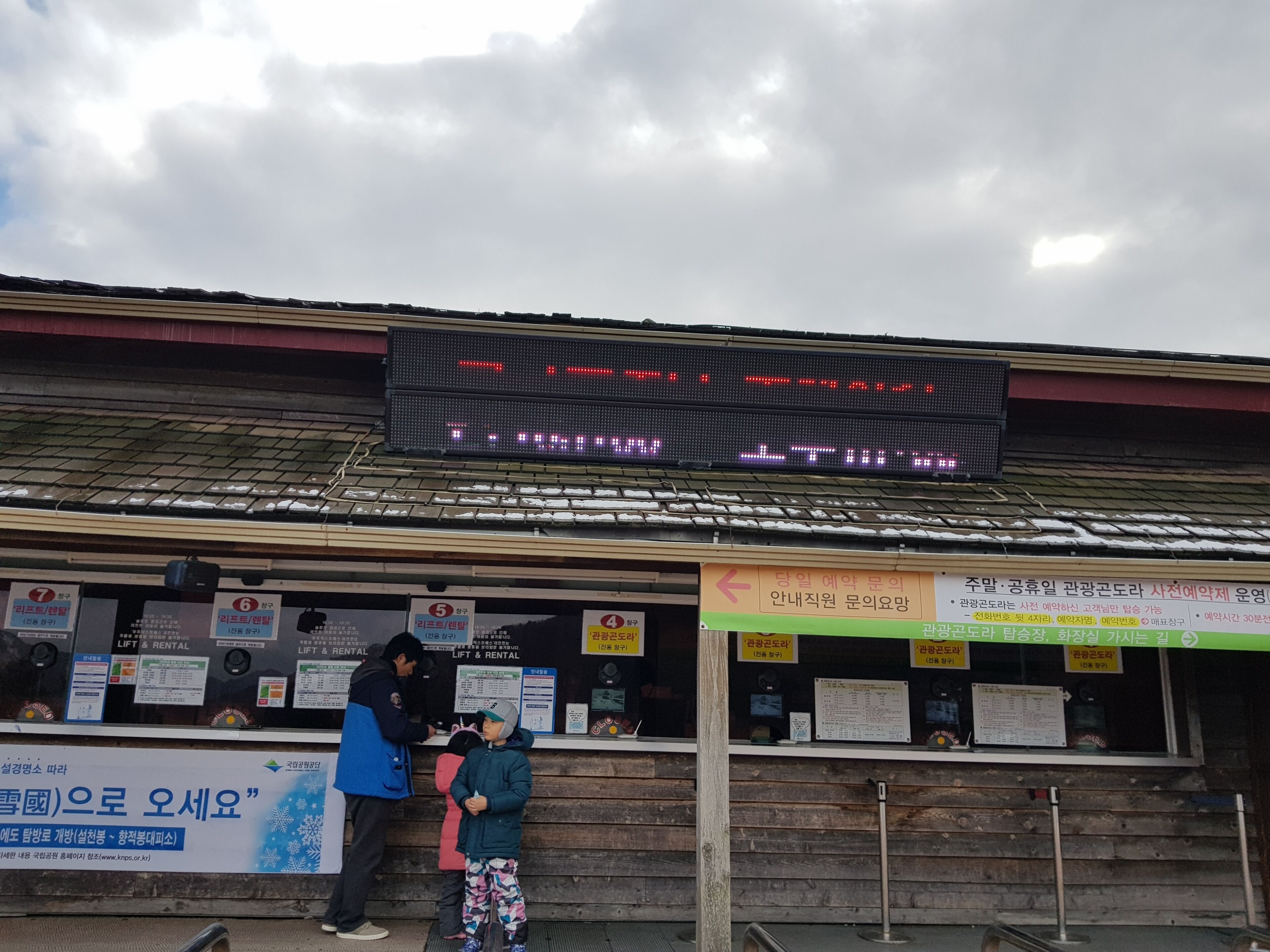 A building with a digital display and signs in Korean.