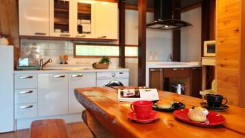 A cozy kitchen with wooden cabinets, a wooden table with a red placemat, and a bench.