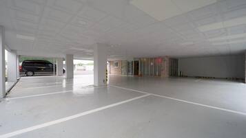 A spacious indoor parking area with a van parked in the background.