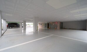 A spacious indoor parking area with a van parked in the background. - February Hotel Busan Gangseo Annex Building  (Busan)