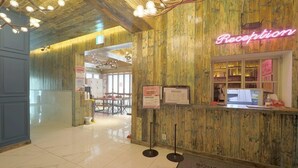A reception area with a wooden wall and a neon sign reading "Reception". - February Hotel Busan Gangseo Annex Building  (Busan)