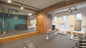 A gym with exercise equipment, a bench, and a mirror. - February Hotel Busan Gangseo Annex Building  (Busan)