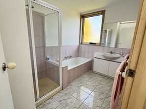 Bathtub, hair dryer, soap, shampoo - Ocean Grove Getaway - Holiday Home (Ocean Grove)