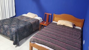 Een kamer met twee bedden, een houten stoel en een klein tafeltje.