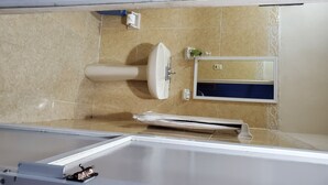 Een badkamer met een bad, een wastafel en een spiegel.