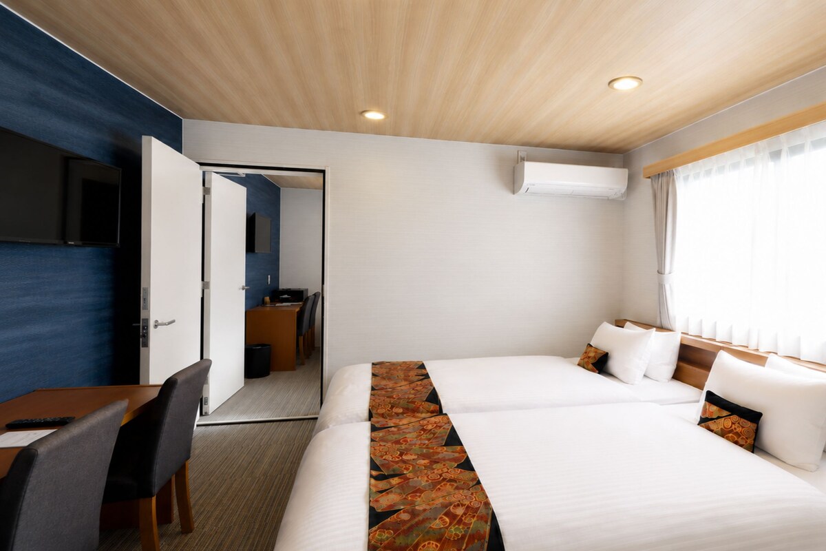 Una habitación de hotel con una cama, un escritorio, una silla y un televisor.