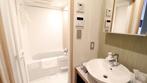A modern bathroom with a bathtub, a sink, and a mirror.