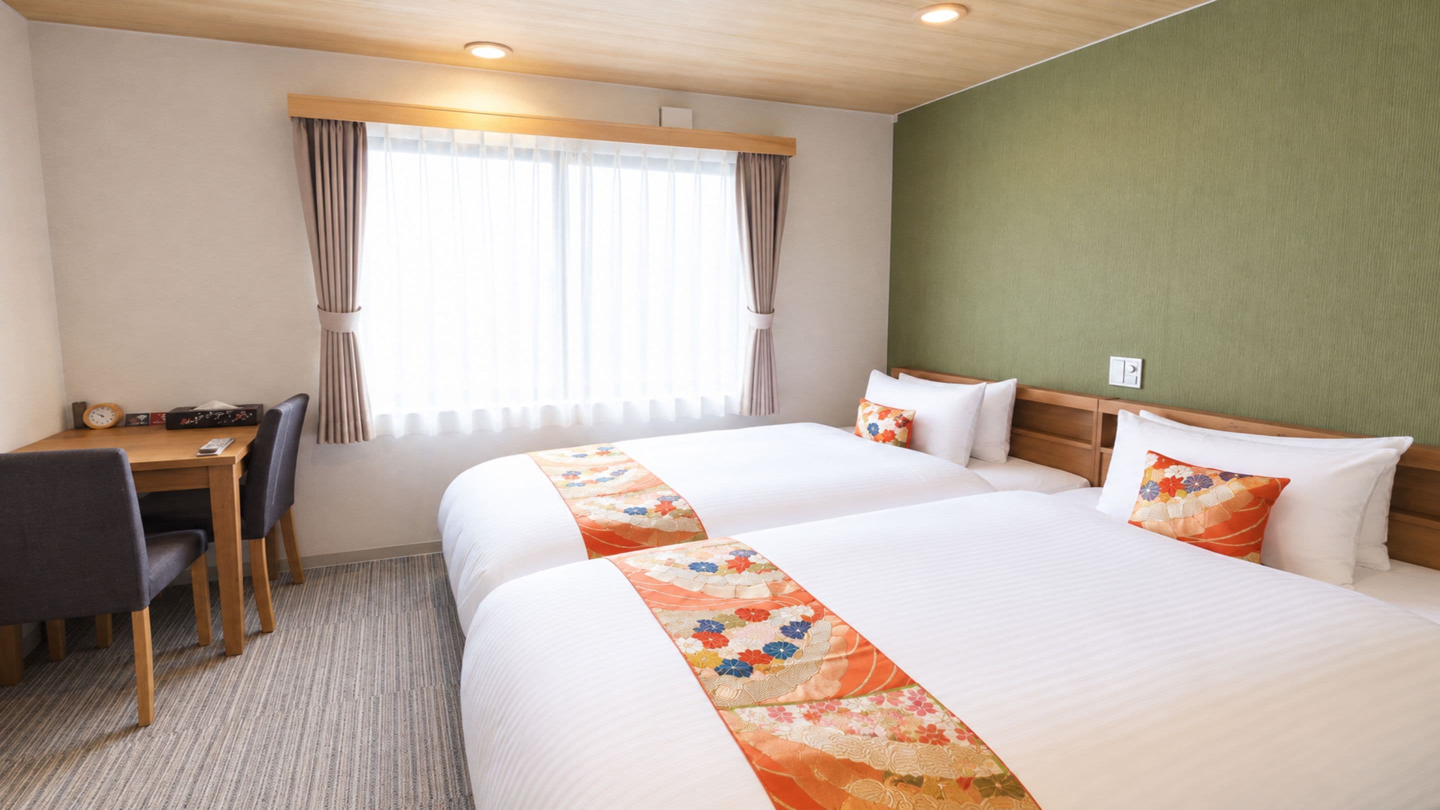 A hotel room with a bed, a desk, and a chair.