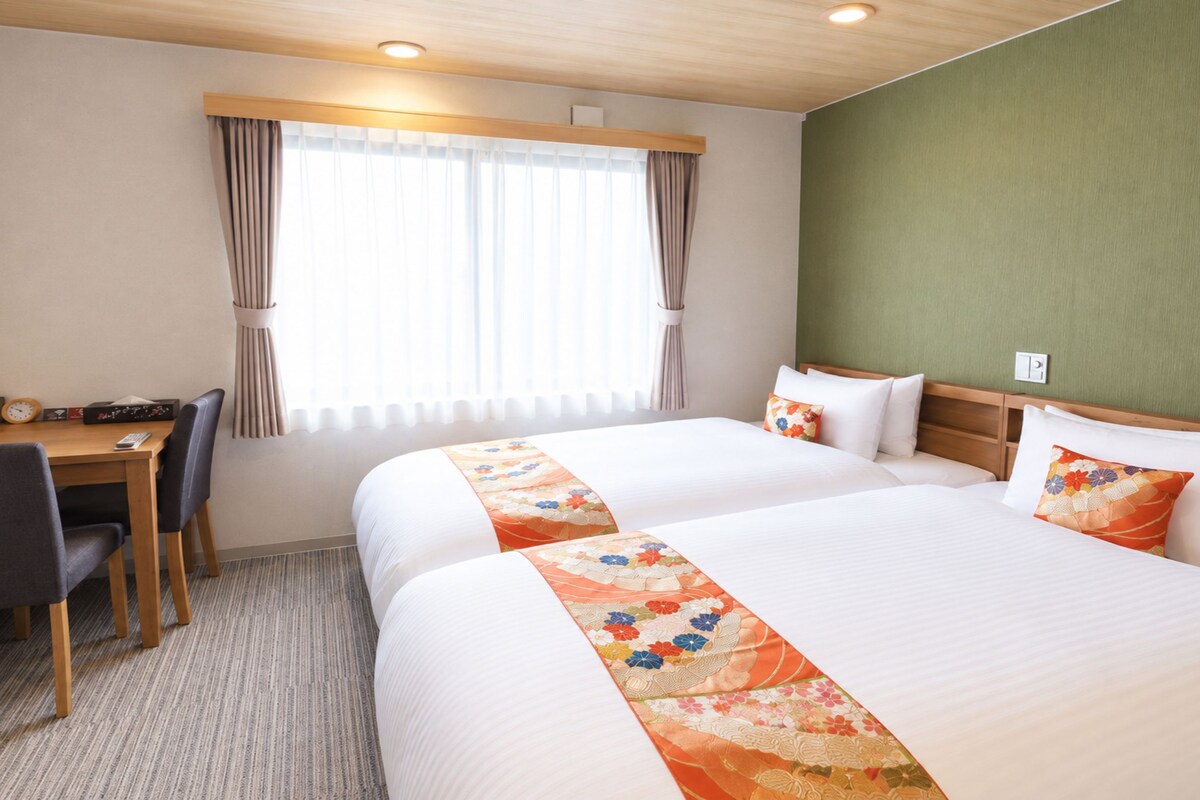 Una habitación de hotel con una cama, un escritorio y una silla.