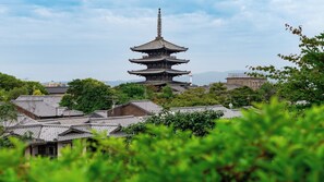 Una pagoda japonesa tradicional con varios niveles, rodeada de edificios residenciales con tejados de tejas.
