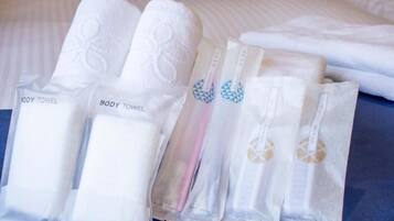 Um conjunto de toalhas de banho dobradas com diferentes estampas, incluindo uma toalha azul, todas identificadas como 'BODY TOWEL'.