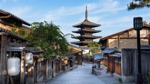 Una calle tradicional japonesa con edificios de madera y una pagoda.