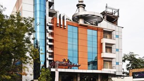 Un hotel de diseño moderno, con una destacada torre cilíndrica y una estructura similar a una cúpula en el techo.
