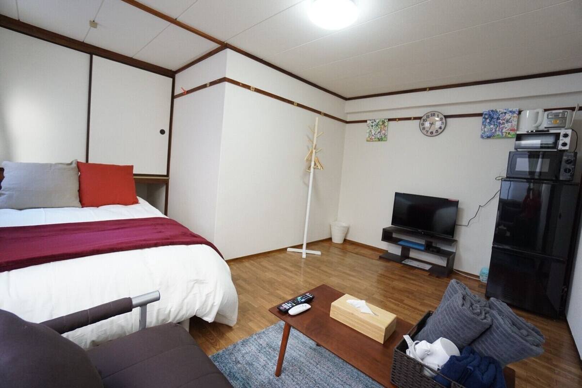 Une chambre d’hôtel équipée d’un lit, d’une télévision, d’un four à micro-ondes et d’un réfrigérateur.